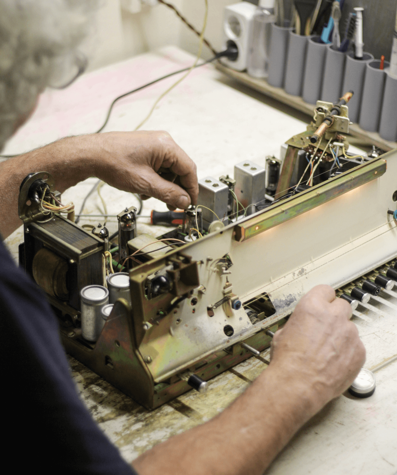 Мастер припаивает регулятор громкости для радиолы «Ригонда 102»