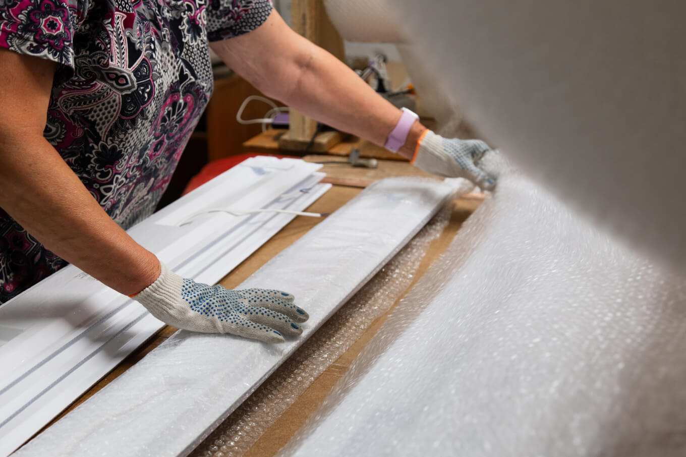 Работники оборачивают светильники в пузырчатую пленку