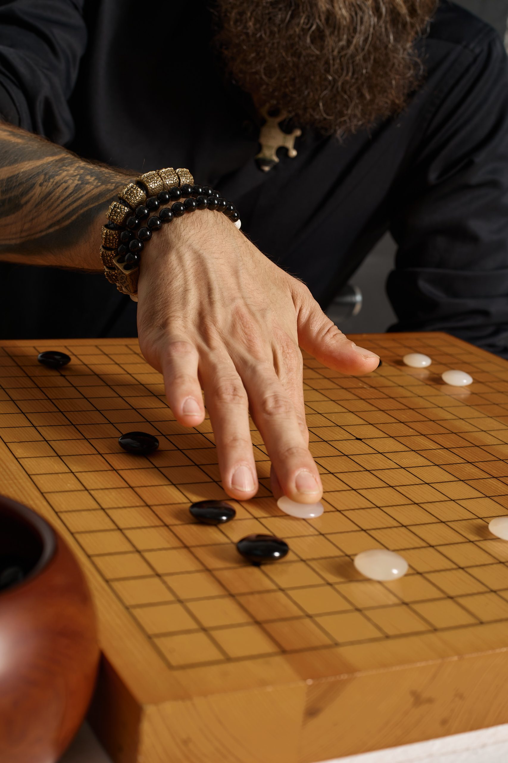 Черные и белые камни в Го символизируют игрока и его коллективного соперника