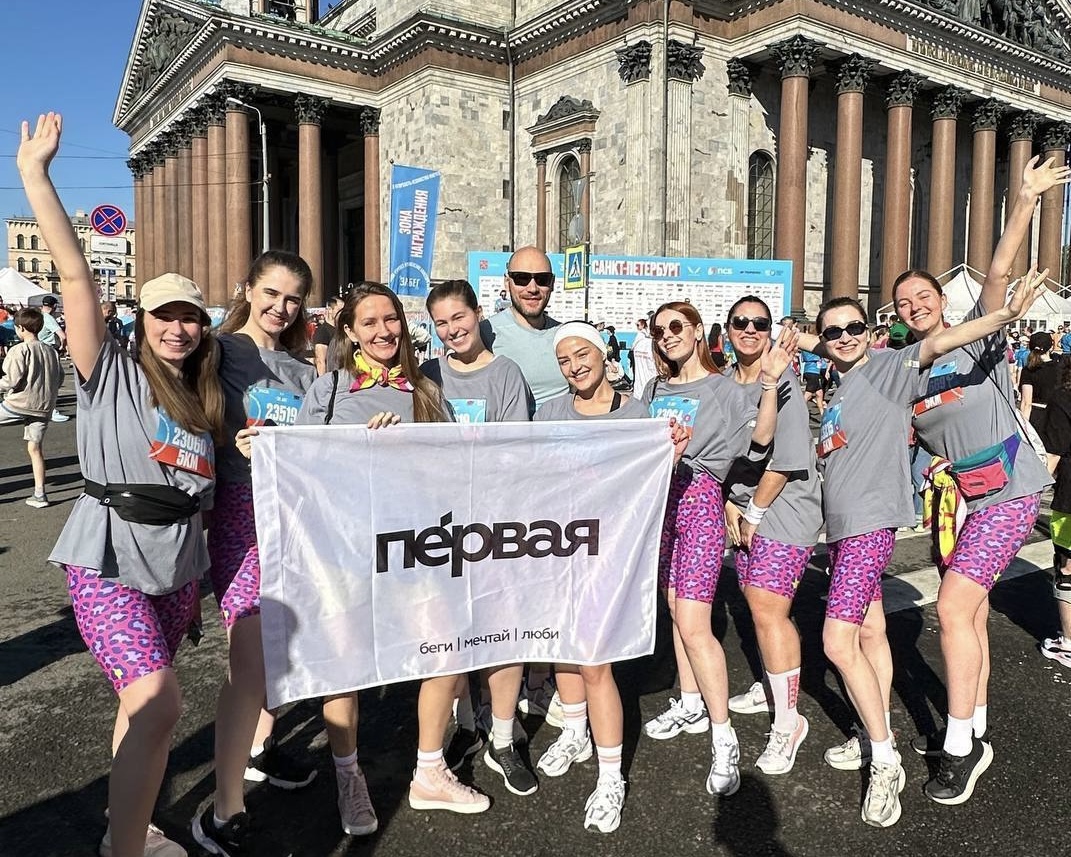 Команда «Первой» с флагом в руках на «Забеге РФ» в Санкт-Петербурге