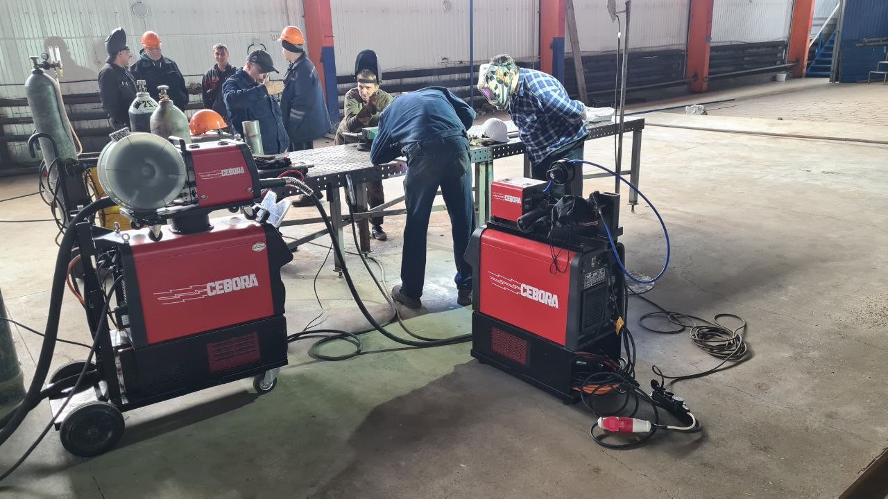 На изображении специалисты Cebora проводит пусконаладочные работы с двумя сварочными аппаратами