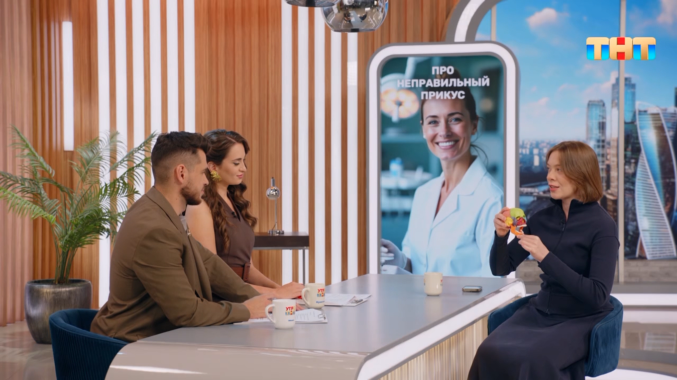 трое человек сидят за белым столом