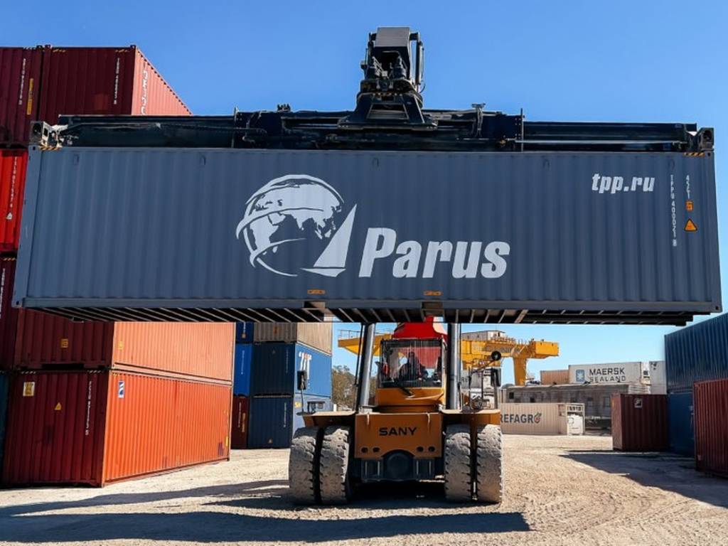 Контейнер компании “Парус” в процессе перегрузки на терминале во Владивостоке.