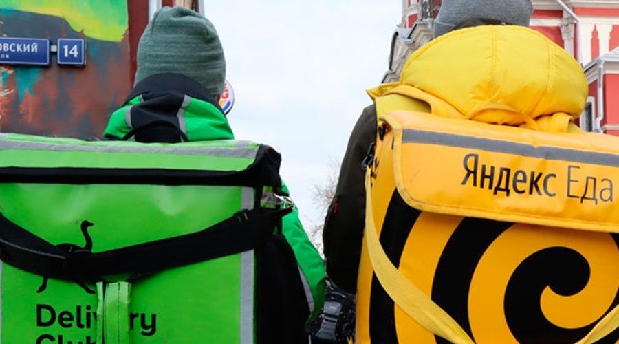 2 курьера Деливери Клаб и Яндекс Еды идут доставлять заказы по улице Москвы