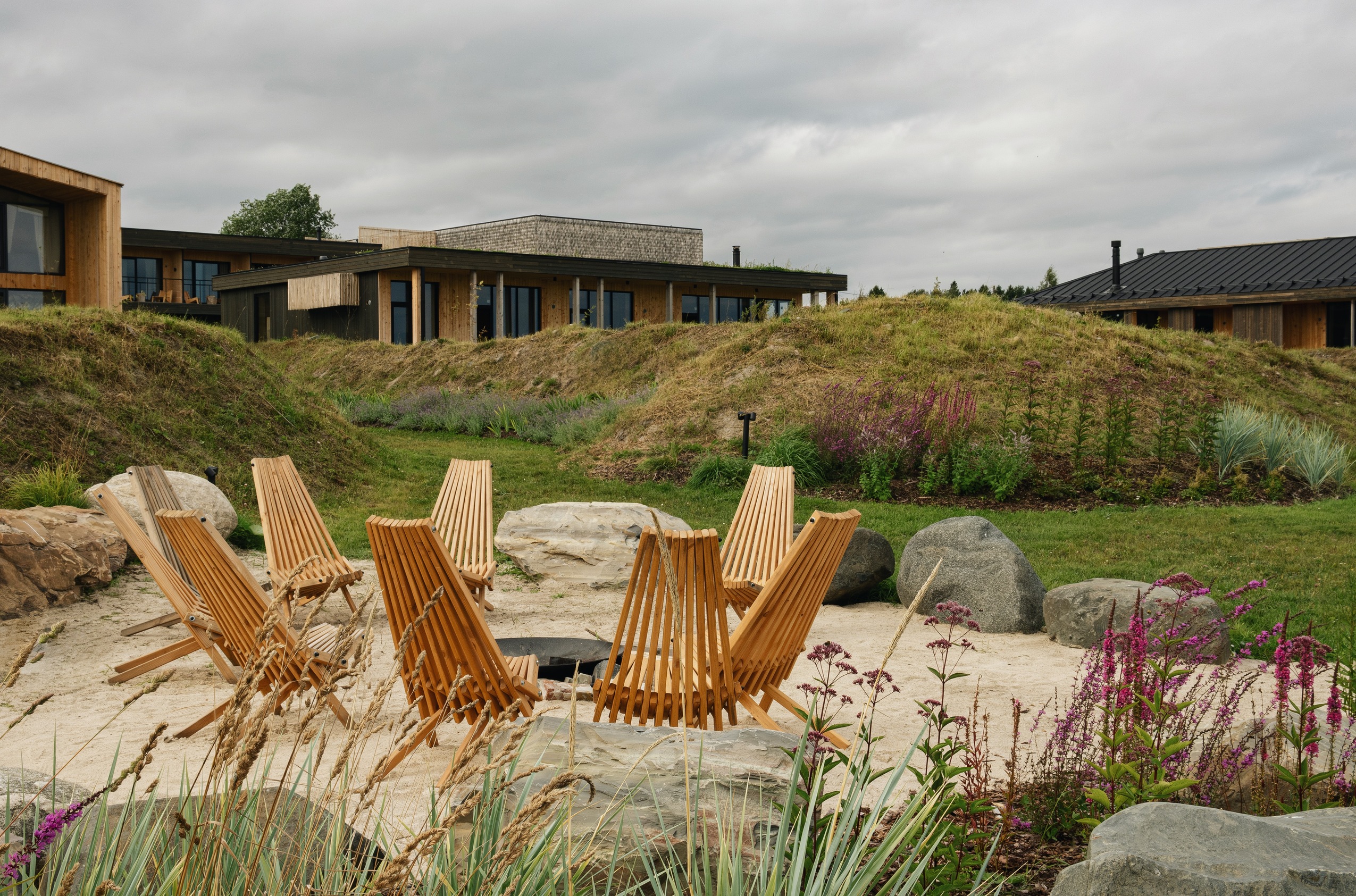 Фото костровой зоны на территории бутик-отеля «Заонежье» с видом на кресла и корпуса отеля