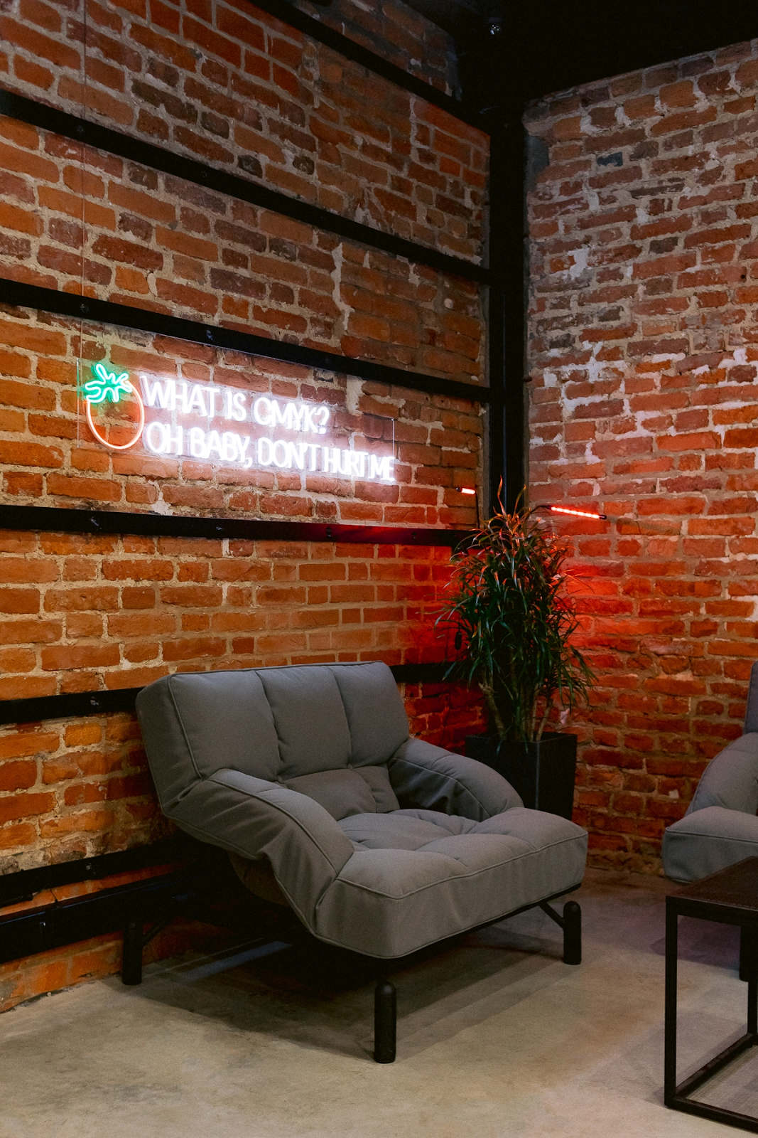 Интерьеры типографии: зона ожидания с диванами и неоновой вывеской