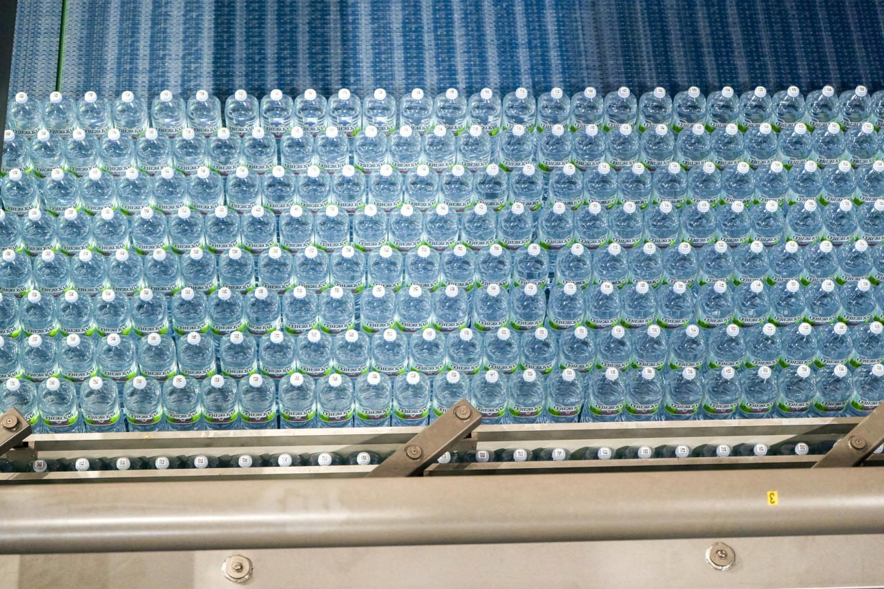 Вид сверху на готовую партию бутылок с водой Сенежская