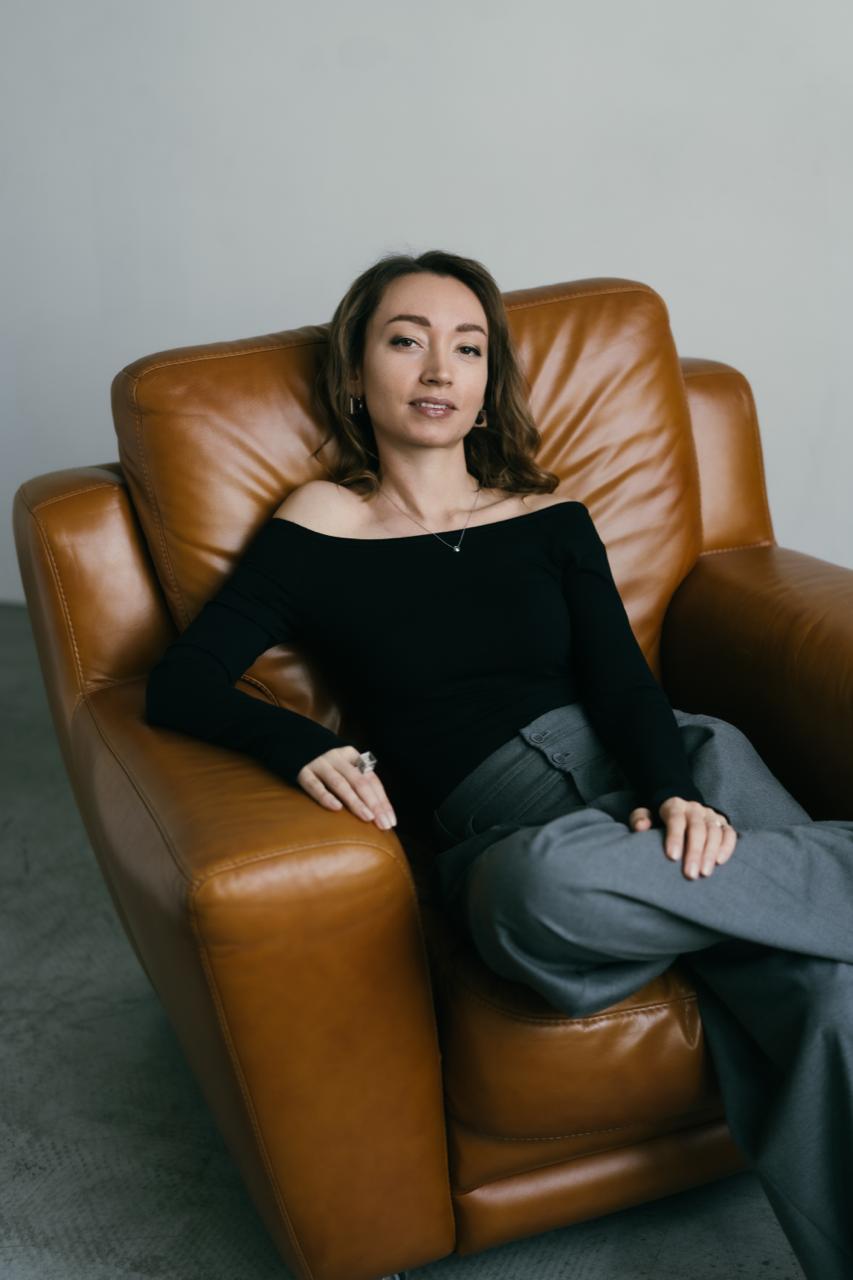 Уверенная в себе девушка расположилась в кожанном кресле