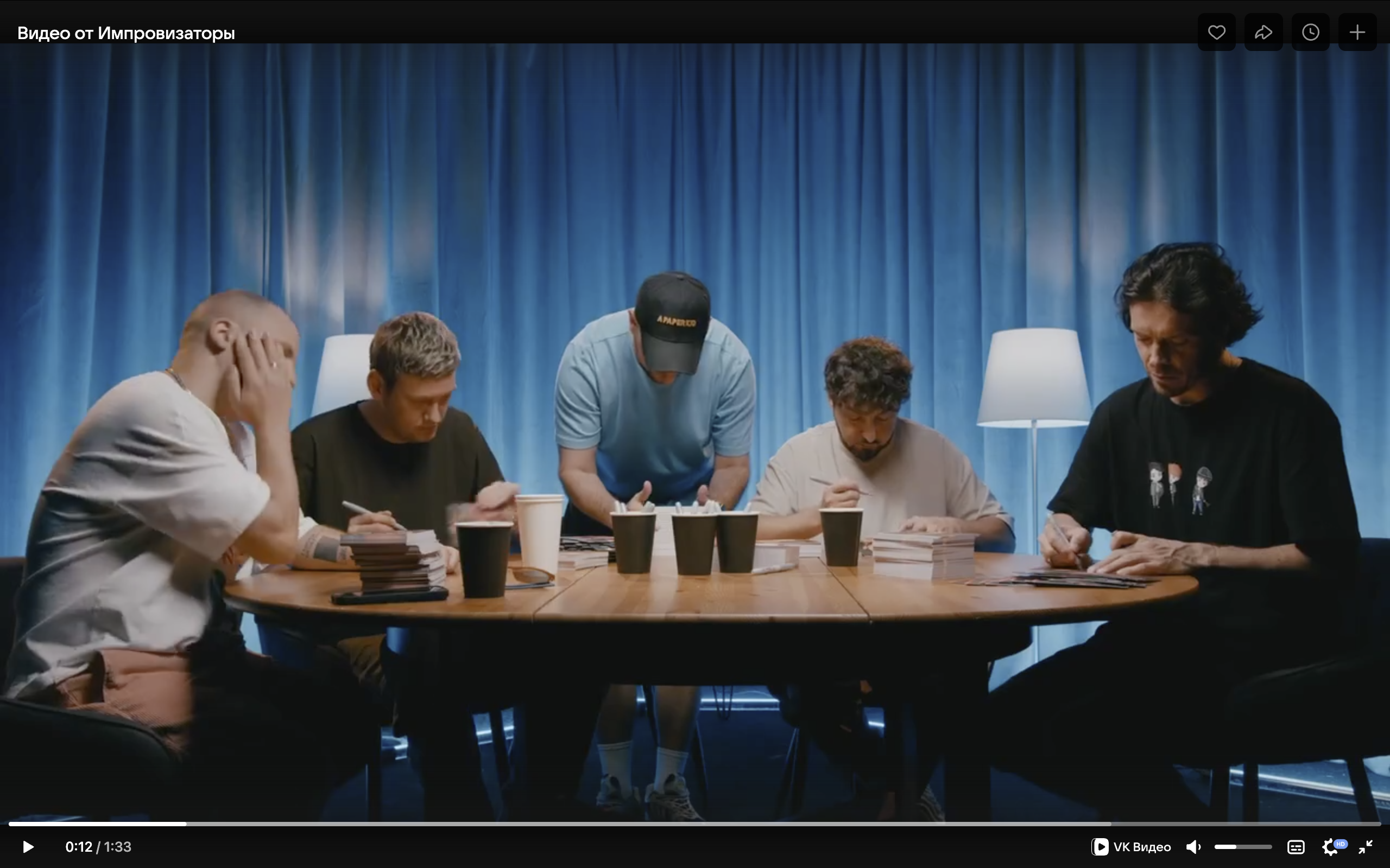 Скриншот видео, в котором участники подписывают открытки