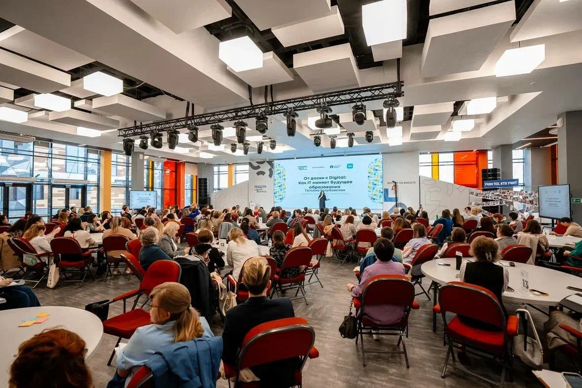 зал полный людей, на сцене выступает спикер