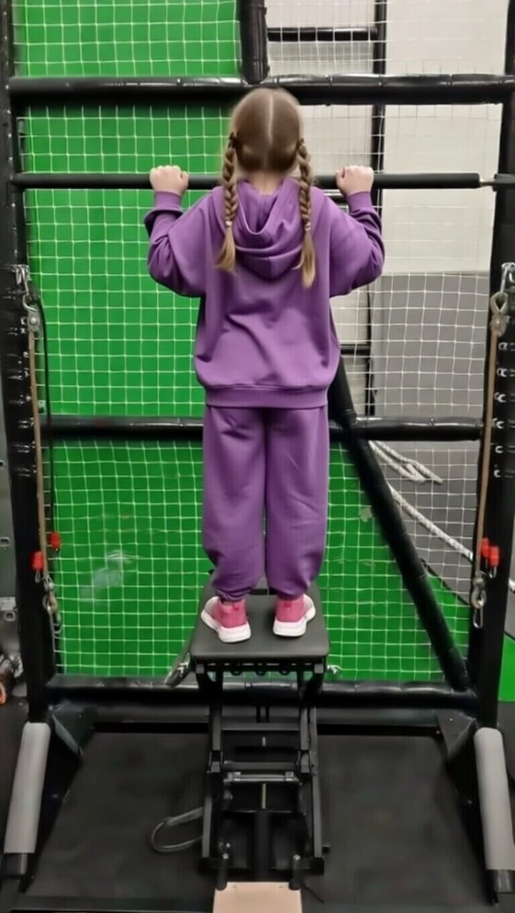 Ребёнок выполняет подтягивание на тренажёре TOMIN с использованием системы контролируемой разгрузки