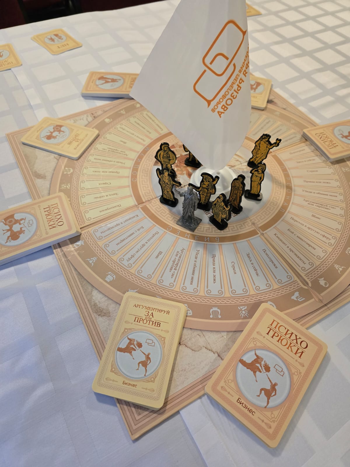 Настольная игра с круговым полем, картами и фигурками игроков, установленными в центре