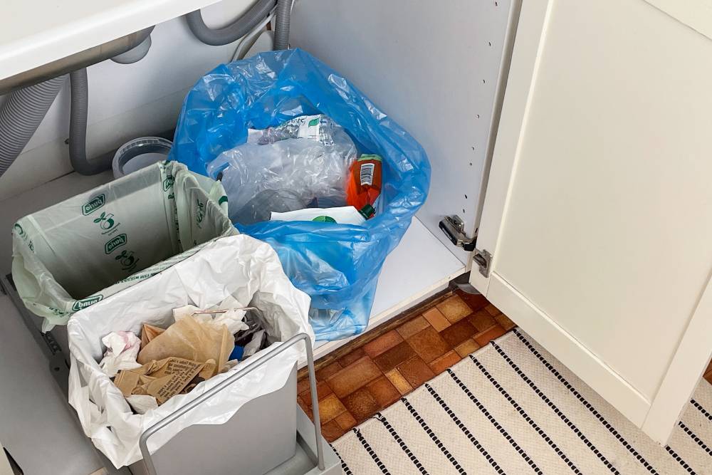 Под раковиной я собираю смешанный мусор. В зеленом пакете — органика, в синем — пластик, а в белом — неперерабатываемый мусор