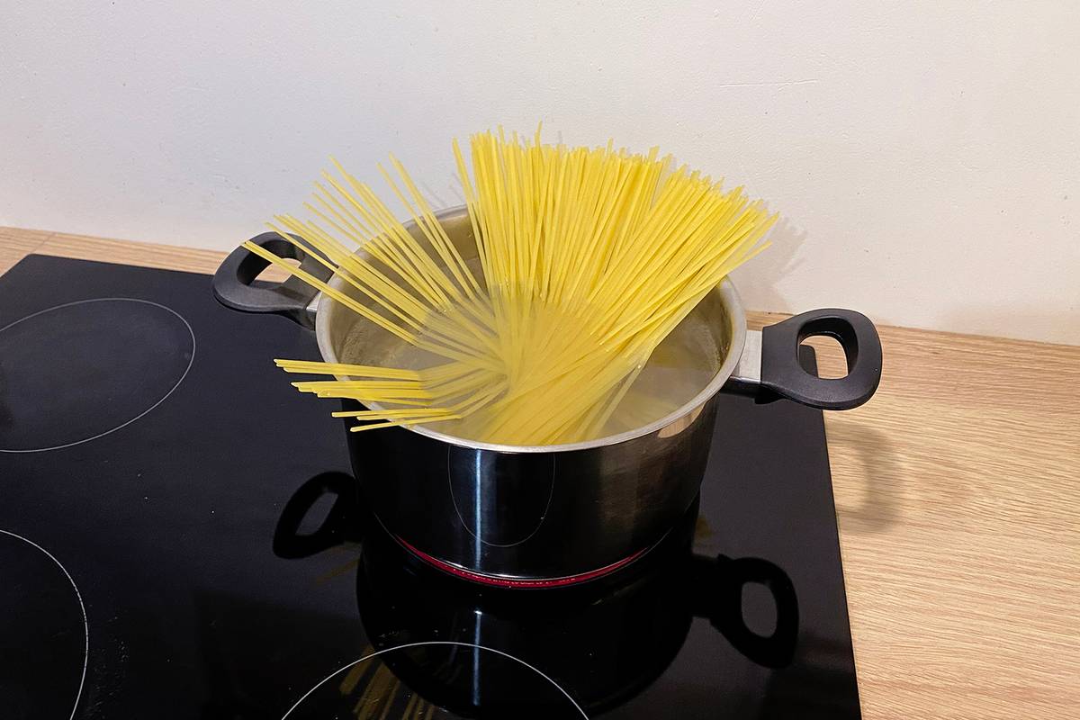 Чтобы спагетти поместились в кастрюлю целиком, поставьте их в кипящую воду и подождите, пока нижняя часть станет мягкой. Потом слегка придавите, чтобы опустить в воду верхнюю часть