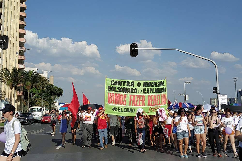 Так в Бразилиа проходили протесты против нынешнего президента Жаира Болсонару перед выборами. На&nbsp;плакате написано: «Против мачизма, Болсонару и&nbsp;эксплуатации. Давайте устроим бунт!»