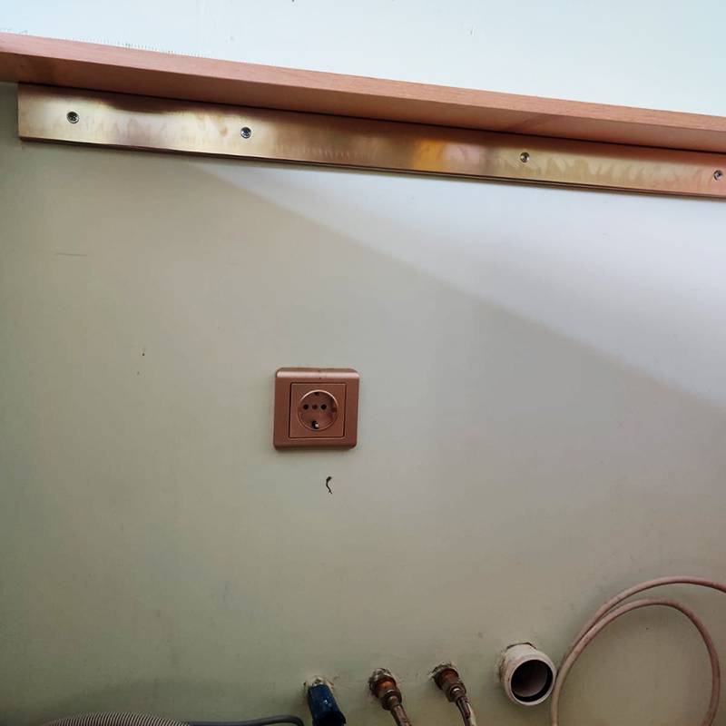 Тонкое место кухонного гарнитура в районе мойки усилили металлической рейкой, прикрепив ее к стене