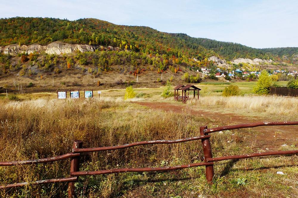 Один из кемпингов на окраине Ширяева: забор, две беседки, кострище и вода в роднике