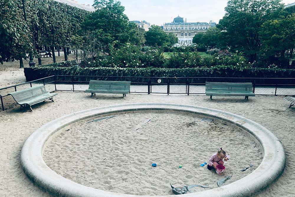 Редкая песочница в центре Парижа, зато с видом на бывший королевский дворец. На фото — дочь Игоря Лея. Она занята тем, что ест песок из ведерка