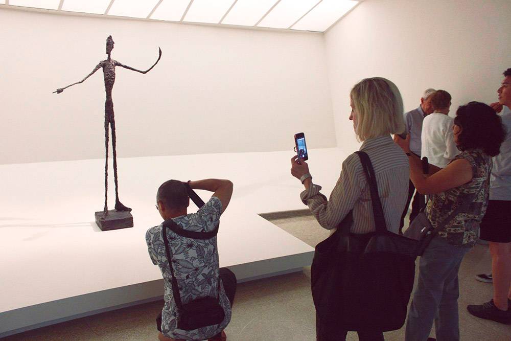 Посетители фотографируют скульптуру «Человек указующий». Всего в мире шесть подобных скульптур. Одну продали на аукционе «Кристис» за 141 285 000 $ (9 211 782 000 <span class=ruble>Р</span>)
