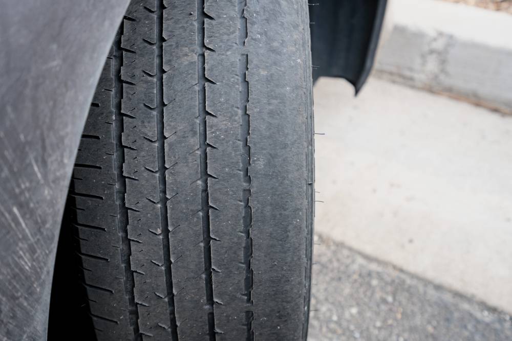 Вероятно, неравномерный износ шины случился из-за неправильного угла установки колес. Если не отрегулировать схождение и развал на автомобиле, новая шина тоже быстро сотрется. Источник: Steve Heap / Shutterstock