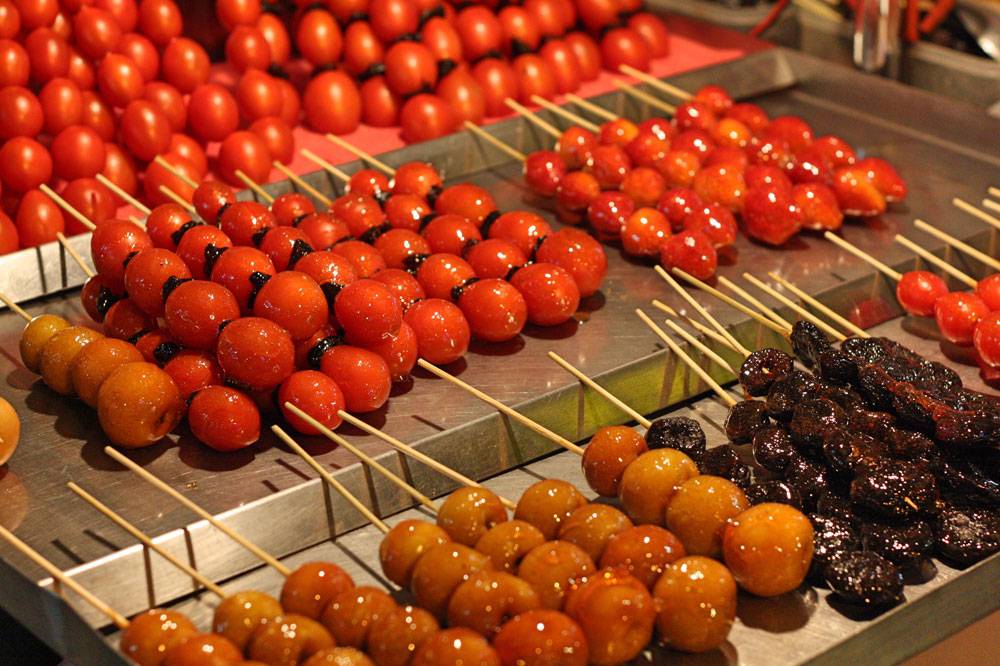Отдельная экзотика — попробовать еду, которой торгуют на ночных рынках. Слева помидоры, справа клубника, снизу яблоки — все это в карамели