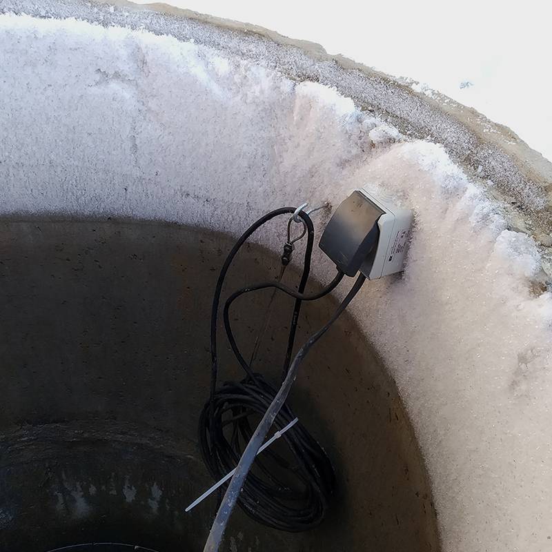 Розетка запитана от кабеля, который я протянул в канаве, когда укладывал водопроводную трубу. В розетку подключен насос. У насоса был довольно длинный кабель для подключения — его мы смотали и повесили на крючок