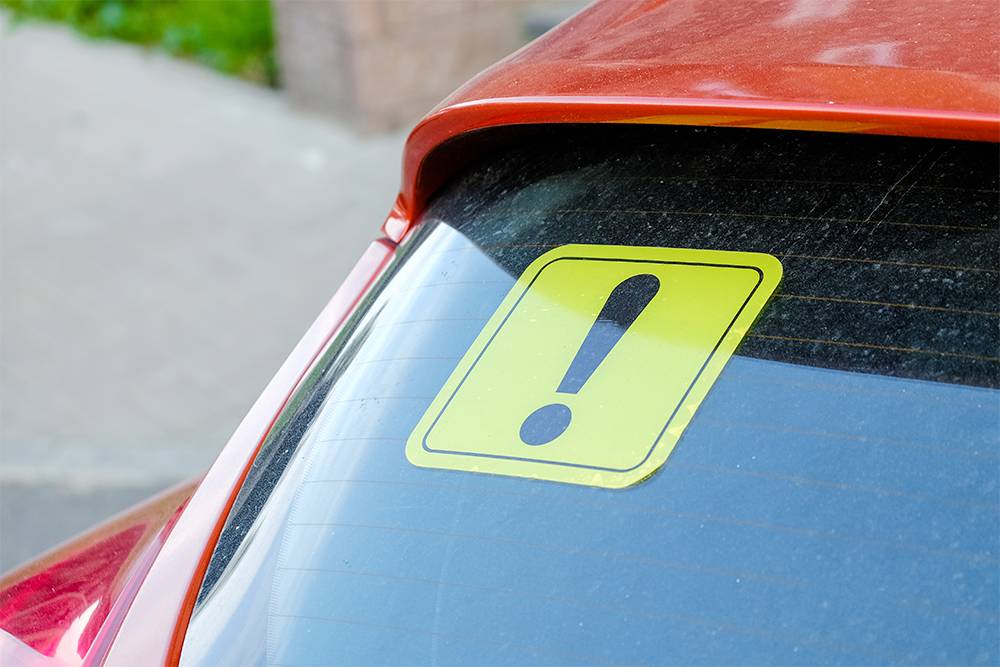 Знак «Начинающий водитель» на заднем стекле может послужить дополнительной приманкой для&nbsp;мошенников: если автомобилист за рулем недавно, даже сдутое колесо может вызвать панику. Источник: ilikeyellow / Shutterstock