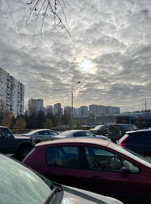 Плотно припаркованные машины вдоль дороги на улице Генерала Кузнецова перед светофором на Новорязанское шоссе