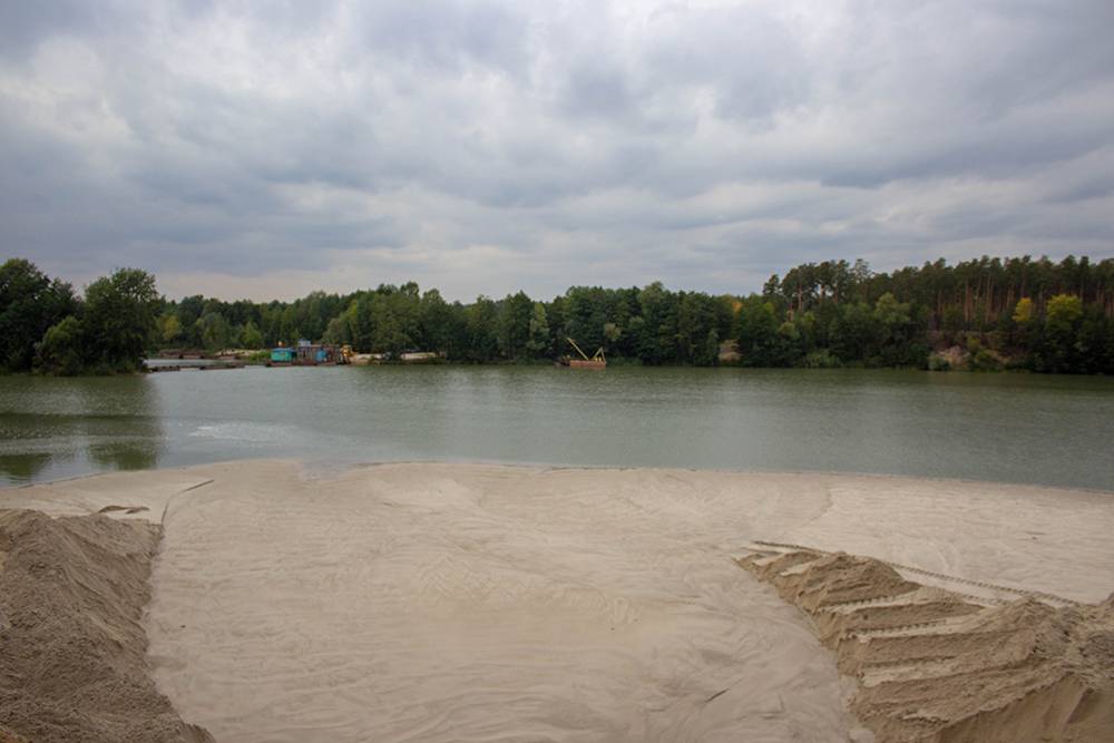 Добыча песка на Силикатных озерах продолжается, и на противоположном берегу видно спецтехнику