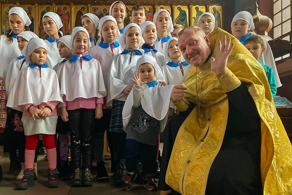 Дети вместе с иереем Евгением Будариным. Фото сделано после Рождественской литургии