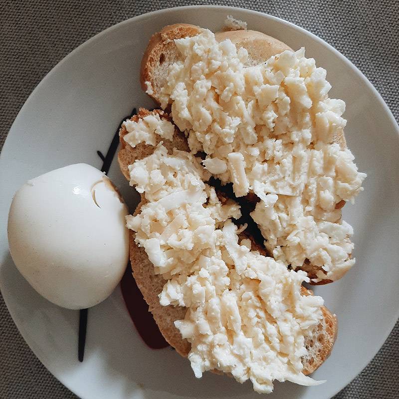 Сегодня у меня кофе с молоком, вареное яйцо и салат из сыра с чесноком на кусочке хлеба. Салат вчера купил папа