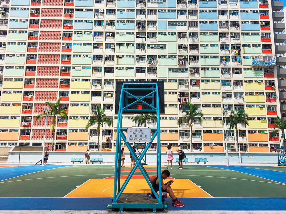 В Гонконге много фотогеничных зданий, но часто условия жизни в них не такие радужные. Название этого жилого комплекса переводится как «радужный дом». Эта баскетбольная площадка находится на крыше автостоянки, большинство людей приходит сюда сделать фотографии