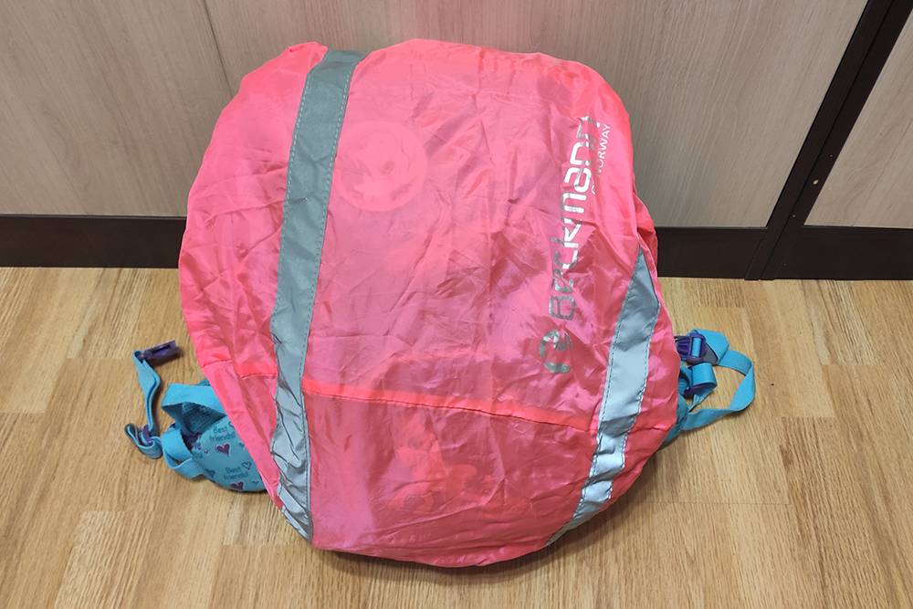 У рюкзака много карманов на молнии, есть лампочка и розовый дождевик, который прячется в верхней крышке