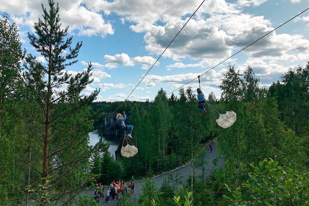 Со стороны полет на троллее выглядит очень круто. К туристам цепляют парашюты, чтобы медленнее летели