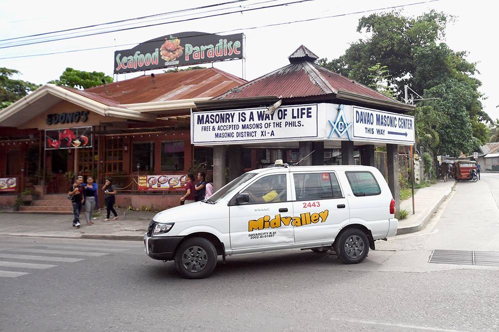 Такси на фоне указателя Масонского центра