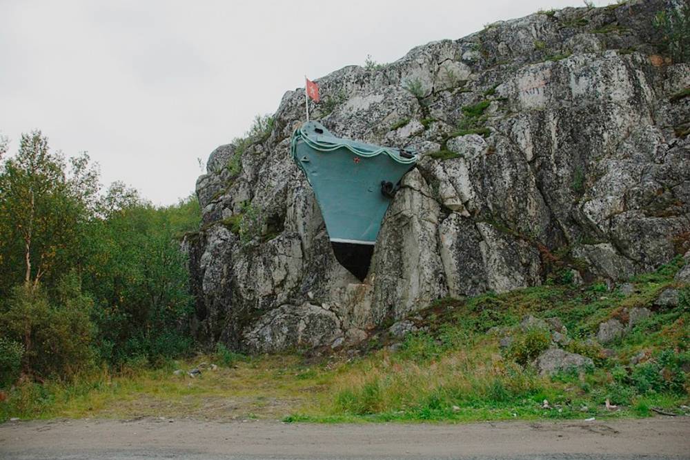 В поселке установлен памятник в честь военных заслуг моряков — нос корабля в скале