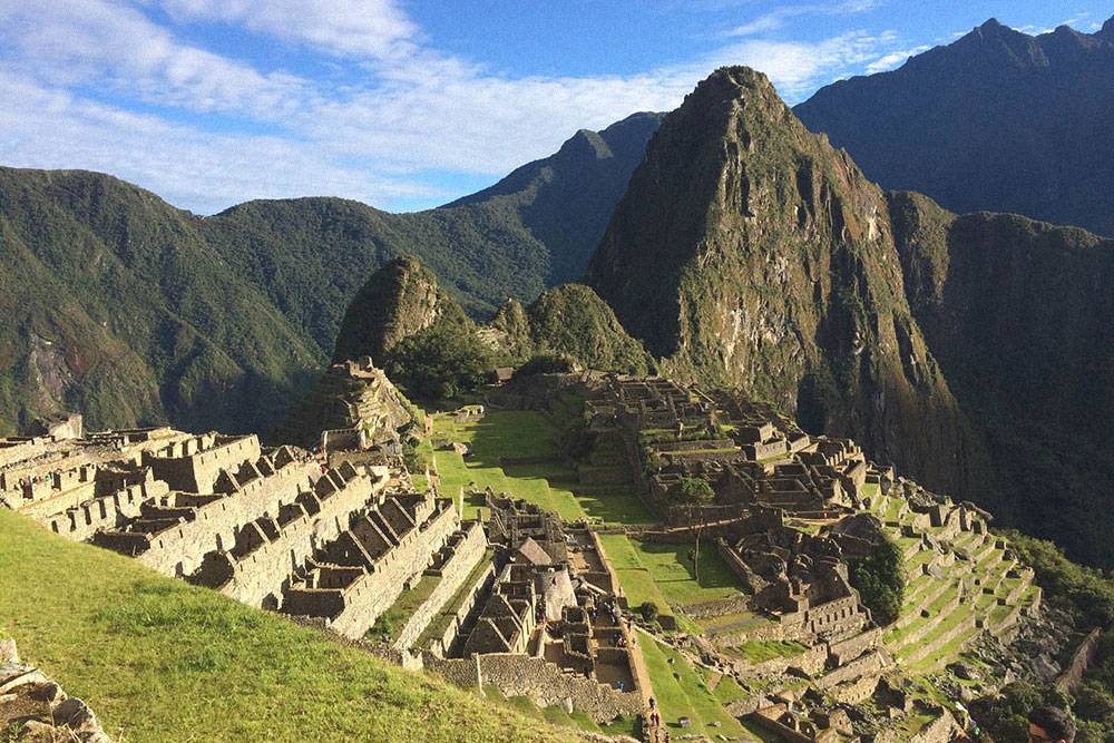 Мачу-Пикчу находится на высоте 2450 метров над уровнем моря. Отвесная скала за руинами города — Уайна-Пикчу, туда любят подниматься туристы