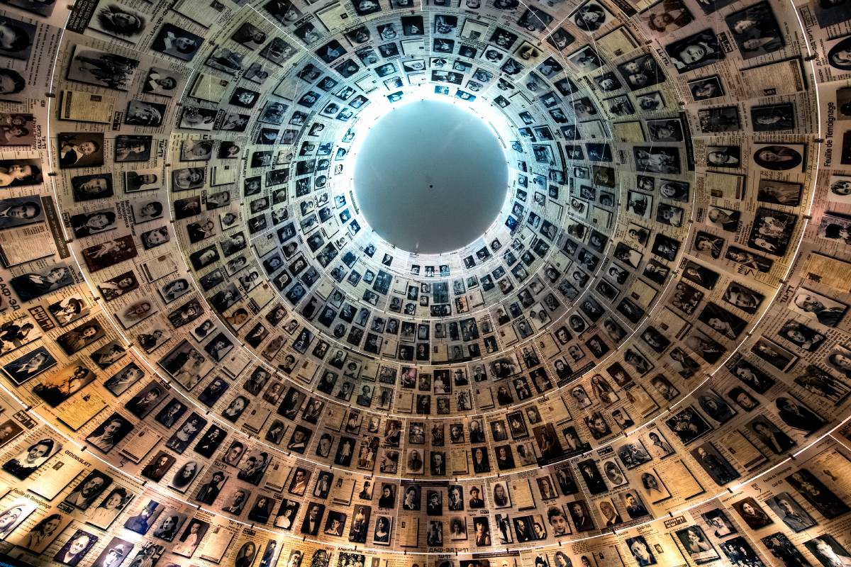 Центральная часть Зала Имен — это вырубленный в скале конус высотой 10 м и глубиной 7 м. На внутренней поверхности верхней части конуса на фоне листов свидетельских показаний разместили более 600&nbsp;портретов погибших. Фото:&nbsp;paparazzza&nbsp;/&nbsp;Shutterstock