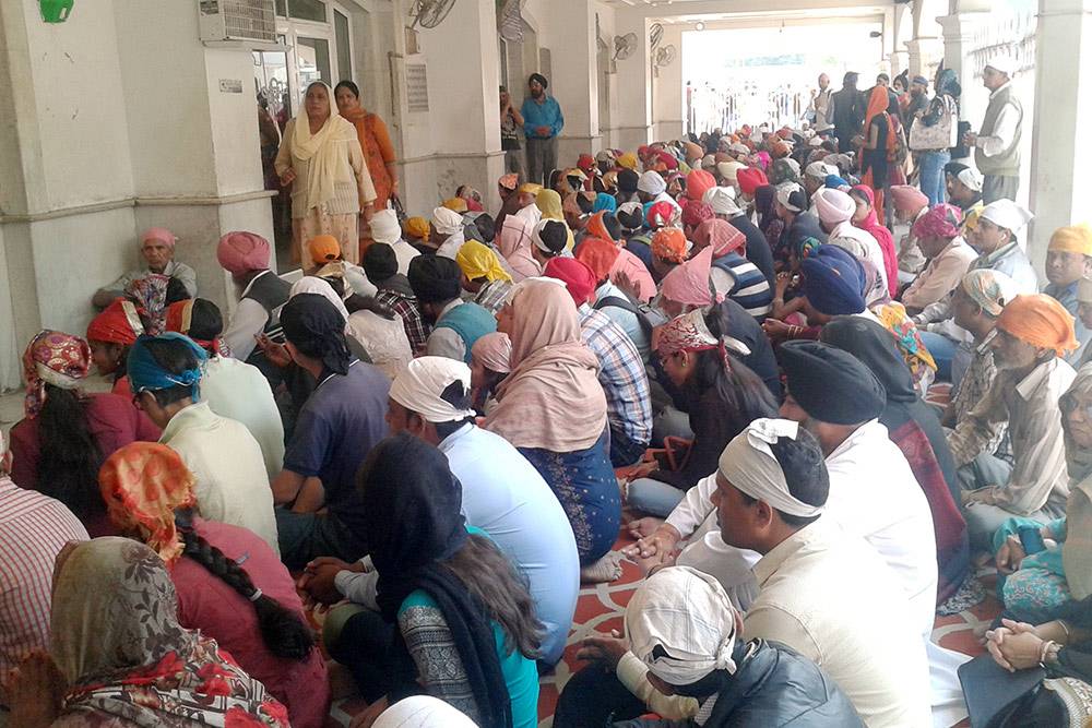 Толпа ждет бесплатного обеда перед столовой сикхского храма в Дели