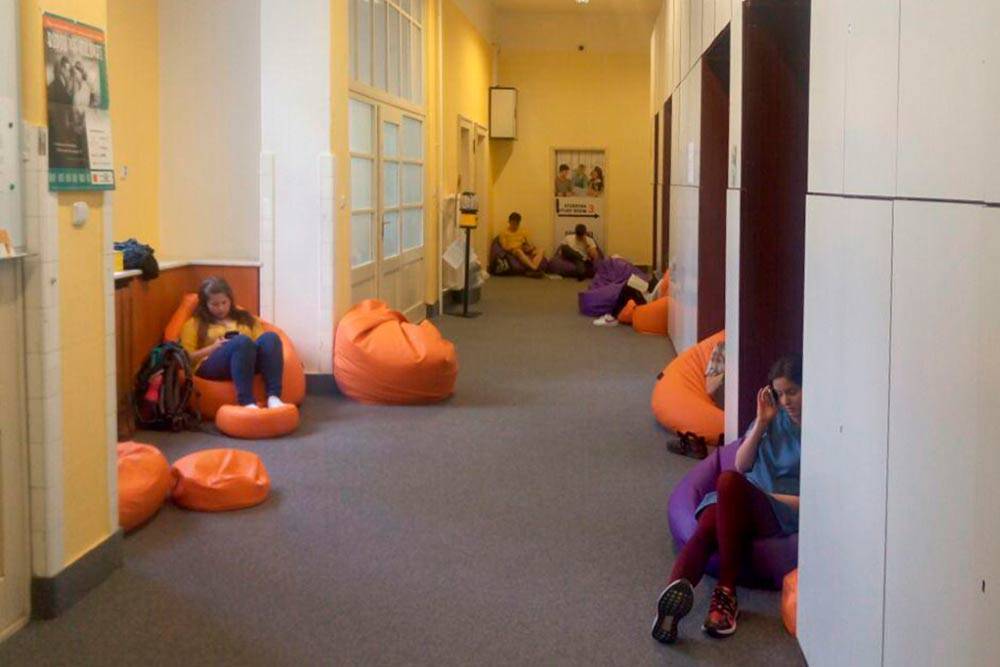 В коридоре учебных комнат студенты общаются, обедают и могут даже поспать в кресле-мешке