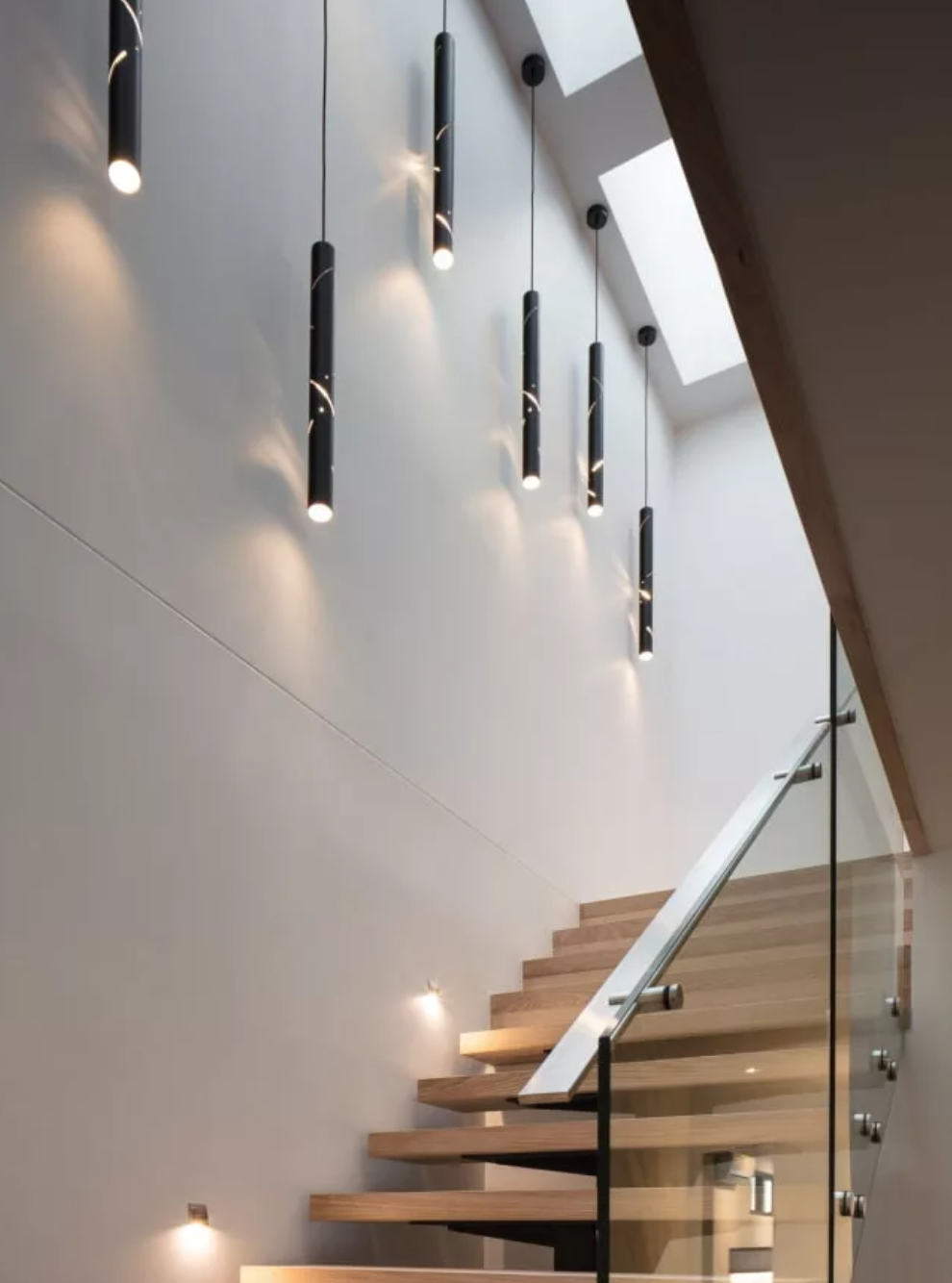 Идею освещения зоны лестницы мы нашли в интернете: вместо встроенных точечных светильников повесили вдоль стены плафоны контрастного цвета. Получилось не как на картинке, но мне нравится. Источник: ledsshop.ru