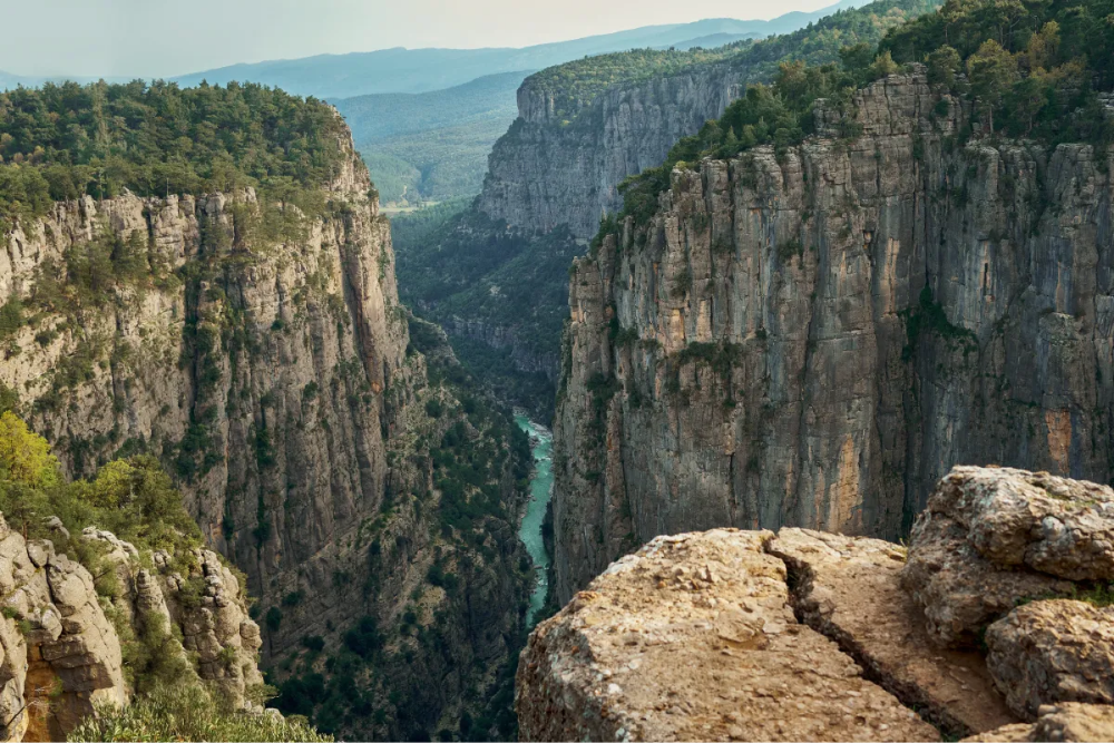 По дну каньона протекает узкая река с водой бирюзового цвета. Фото: Vitalii Matokha / Shutterstock