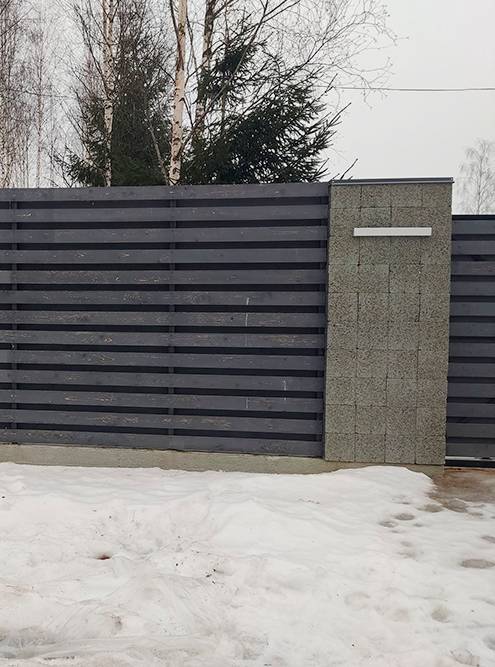 Комбинированный забор из цементных блоков, секции между которыми заполнены деревянными жалюзи