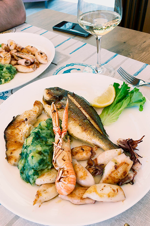 Рыба, лангустин и кальмары на гриле — обычное блюдо в ресторанах на побережье. Очень вкусно: все это еще недавно плавало в море, поэтому свежее, мягкое и нежное