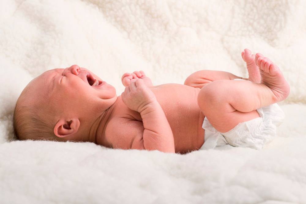 Как выглядят колики у новорожденного: ребенок кричит, губы и кожа вокруг рта бледные, ручки сжаты в кулачки, ножки приведены к животу. Источник: Luck Club