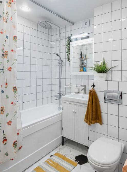 Другой оттенок оранжевого полотенца, который поддержали ковриком и принтом на шторке, смотрится в ванной гармонично. Белая плитка на стенах — прекрасная и недорогая. Источник:&nbsp;inmyroom_ru / Pinterest