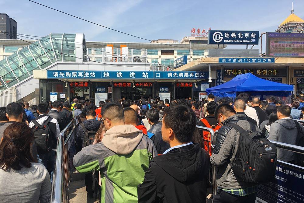 Очередь на вход в метро у центрального вокзала в Пекине. Железные заборы направляют потоки людей к разным входам, чтобы избежать хаоса