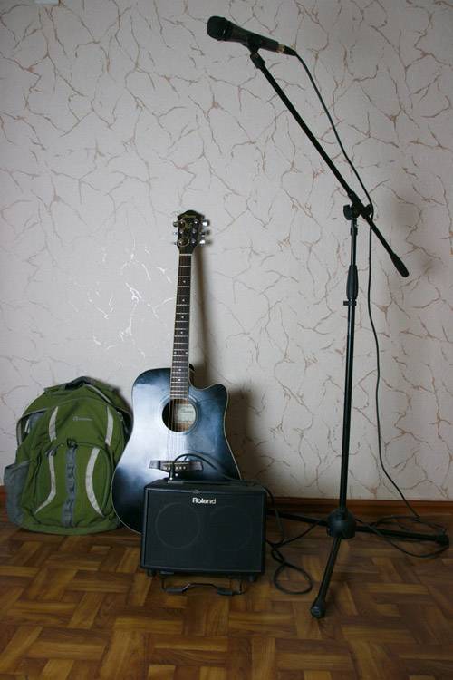 Инструмент и аппарат уличного музыканта Вовы: гитара, переносной усилитель, рюкзак для него, микрофон со стойкой