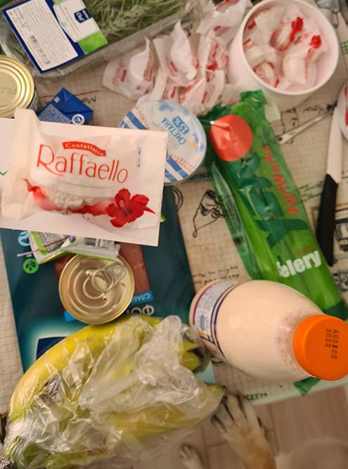 Рафаэлка в качестве подарка на фоне оберток от рафаэлок и лапка собакена, который пришел посмотреть, нет&nbsp;ли там чего-нибудь ему