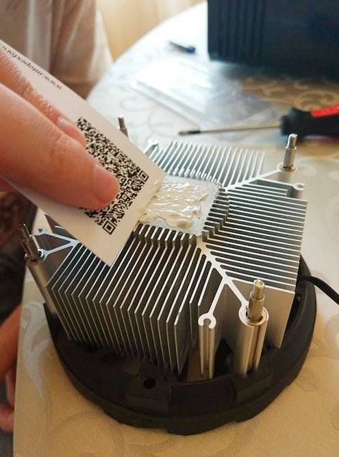 Наносим на кулер термопасту слоем 0,5—1 мм и размазываем картонкой